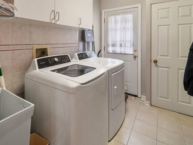 420 Ford Ln, Bartlett, IL 60103 - laundry area featuring washer and dryer, light tile patterned floors, and cabinet space