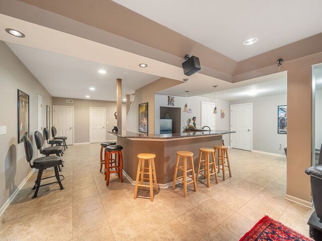 420 Ford Ln, Bartlett, IL 60103 - kitchen with freestanding refrigerator, a breakfast bar area, light tile patterned flooring, and recessed lighting