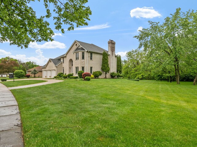 420 Ford Ln, Bartlett, IL 60103 - view of front of property with a chimney, a front yard, concrete driveway, and a garage