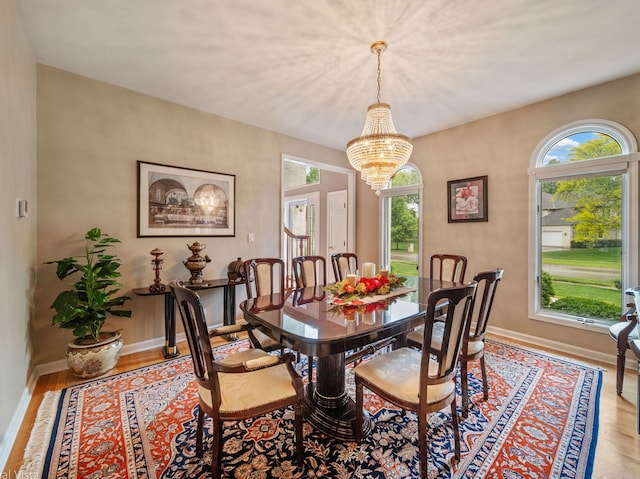 420 Ford Ln, Bartlett, IL 60103 - dining room with healthy amount of natural light, a chandelier, wood finished floors, and baseboards