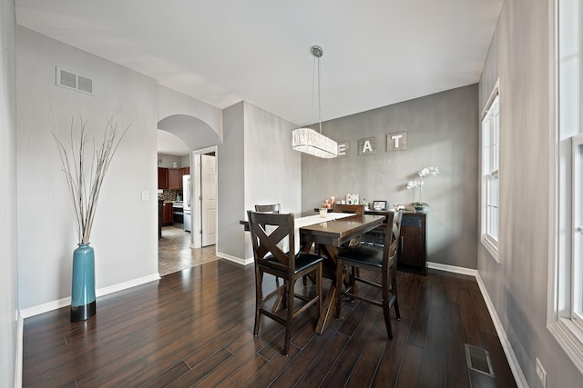 2274 Scotsglen Dr, New Lenox, IL 60451 - dining room with arched walkways, dark wood-style floors, and baseboards