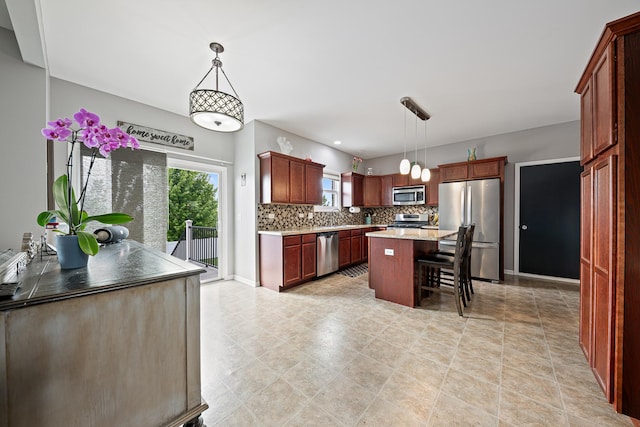 2274 Scotsglen Dr, New Lenox, IL 60451 - kitchen with appliances with stainless steel finishes, backsplash, a breakfast bar area, pendant lighting, and a center island