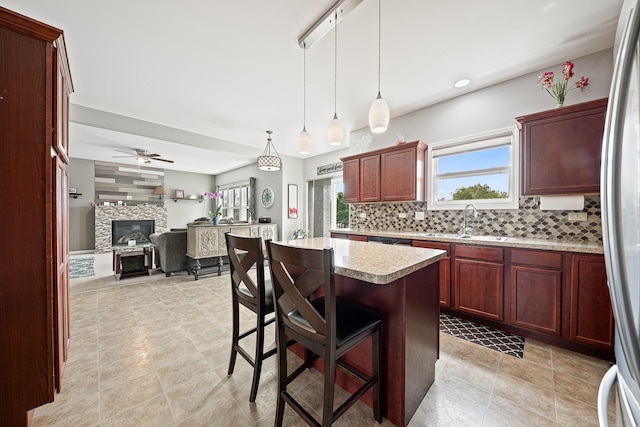 2274 Scotsglen Dr, New Lenox, IL 60451 - kitchen featuring a sink, light countertops, tasteful backsplash, a tiled fireplace, and open floor plan