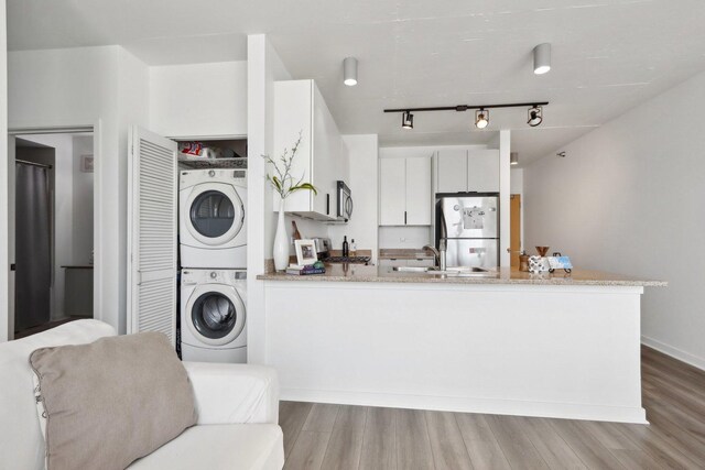 611 S Wells St Unit 2801, Chicago, IL 60607 - washroom with stacked washer / dryer, wood finished floors, and track lighting