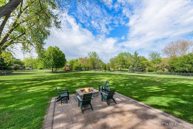 view of patio / terrace with a fire pit and view of wooded area
