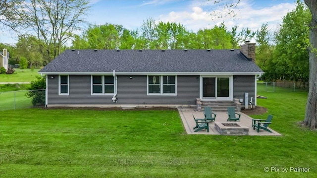 back of house with a fire pit, a patio area, a chimney, and roof with shingles