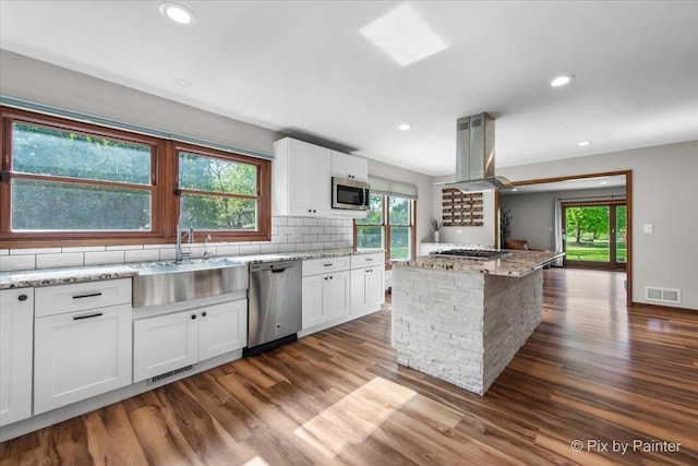 kitchen with stainless steel appliances, a sink, island range hood, dark wood-type flooring, and recessed lighting