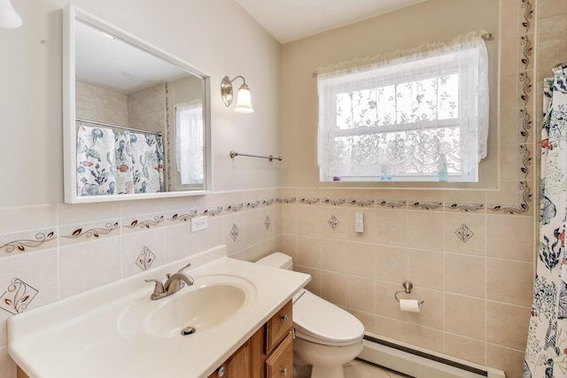 bathroom featuring a baseboard heating unit, plenty of natural light, toilet, tile walls, and vanity