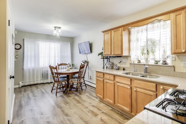 kitchen with a sink, a baseboard radiator, a baseboard heating unit, and light wood-style floors