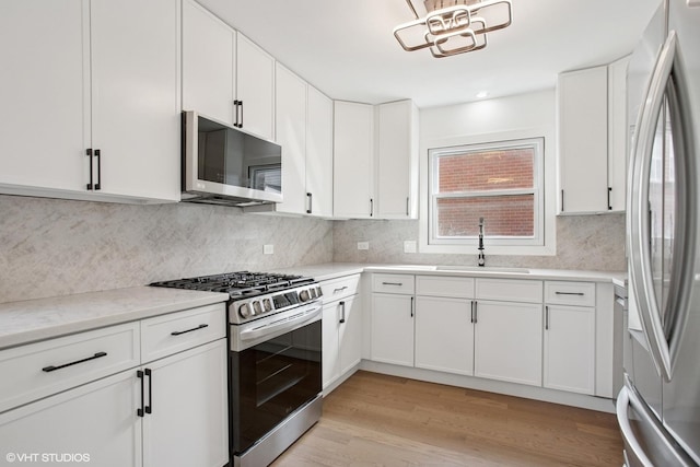2006 Aldrich Pl, Downers Grove, IL 60516 - kitchen featuring appliances with stainless steel finishes, a sink, white cabinets, light wood finished floors, and tasteful backsplash