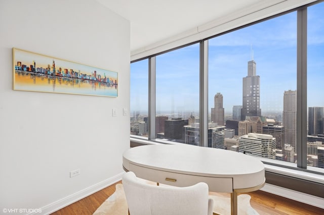 60 E Monroe St Unit 6203, Chicago, IL 60603 - dining room with wood finished floors, baseboards, a city view, and a wall of windows