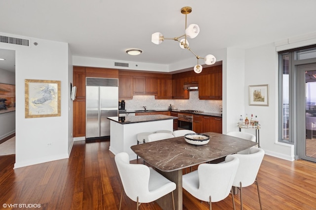 60 E Monroe St Unit 6203, Chicago, IL 60603 - kitchen featuring appliances with stainless steel finishes, a sink, dark countertops, a kitchen island, and dark wood-style floors