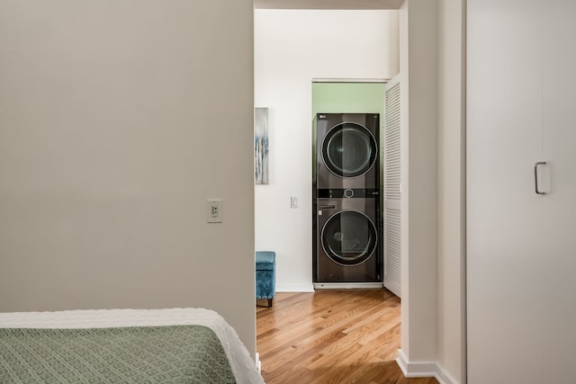 210 S Desplaines St Unit 402, Chicago, IL 60661 - washroom with stacked washer and clothes dryer, light wood-style floors, and baseboards
