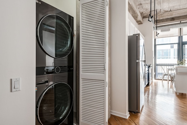 210 S Desplaines St Unit 402, Chicago, IL 60661 - laundry area with estacked washer and dryer, light wood-type flooring, and baseboards