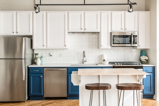 210 S Desplaines St Unit 402, Chicago, IL 60661 - kitchen with appliances with stainless steel finishes, blue cabinets, a sink, and tasteful backsplash