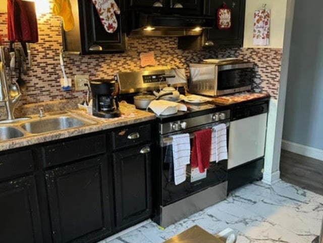 kitchen featuring appliances with stainless steel finishes, dark cabinets, ventilation hood, and tasteful backsplash