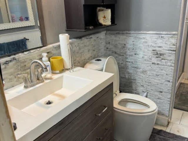 full bath featuring vanity, toilet, a shower stall, and tasteful backsplash