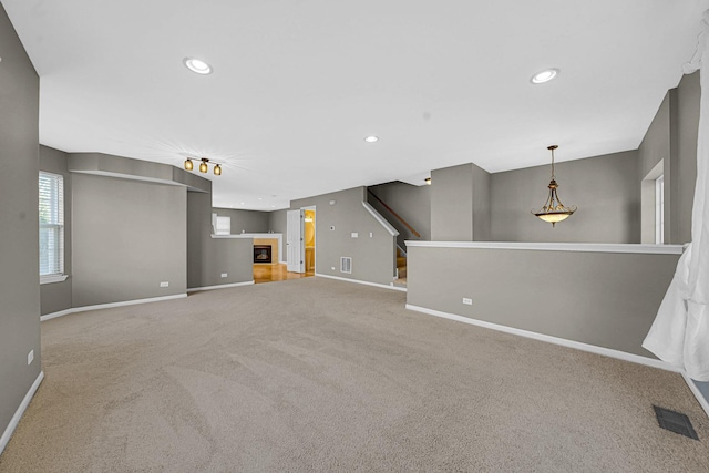 62 E Emma Ct, Palatine, IL 60067 - unfurnished living room featuring carpet, baseboards, a glass covered fireplace, and recessed lighting