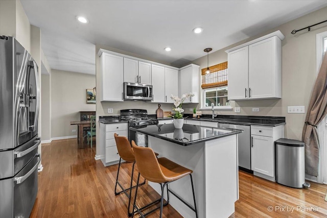 8926 Cook Way, Huntley, IL 60142 - kitchen with appliances with stainless steel finishes, a sink, dark countertops, a breakfast bar, and white cabinetry