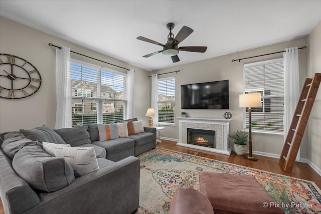8926 Cook Way, Huntley, IL 60142 - living room featuring ceiling fan, wood finished floors, baseboards, and a lit fireplace
