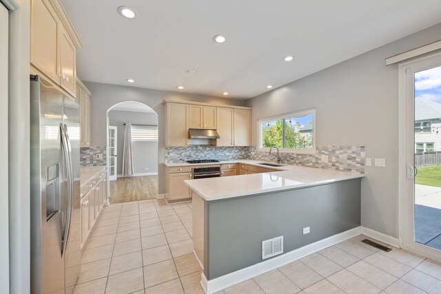 9231 N Natchez Ave, Morton Grove, IL 60053 - kitchen with stainless steel appliances, under cabinet range hood, arched walkways, a sink, and a peninsula