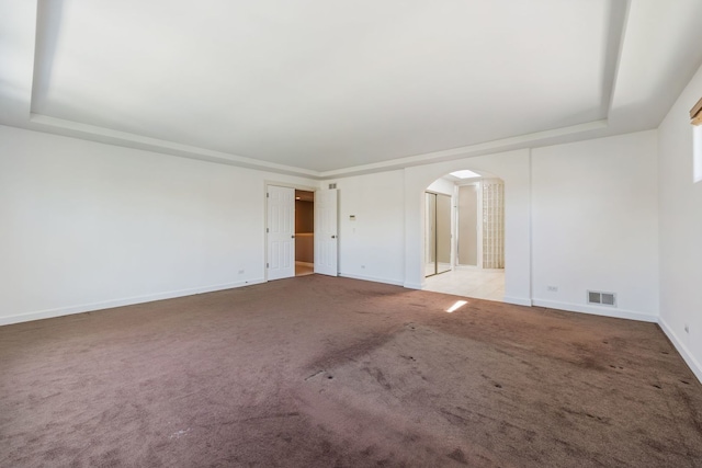 9231 N Natchez Ave, Morton Grove, IL 60053 - carpeted empty room with arched walkways, a tray ceiling, and baseboards
