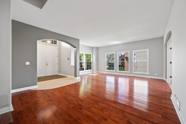 9231 N Natchez Ave, Morton Grove, IL 60053 - unfurnished living room with hardwood / wood-style flooring, arched walkways, and baseboards