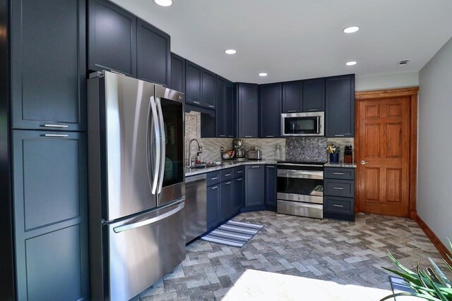 140 Princeton St, Hoffman Estates, IL 60169 - kitchen featuring stainless steel appliances, backsplash, a sink, recessed lighting, and light stone countertops