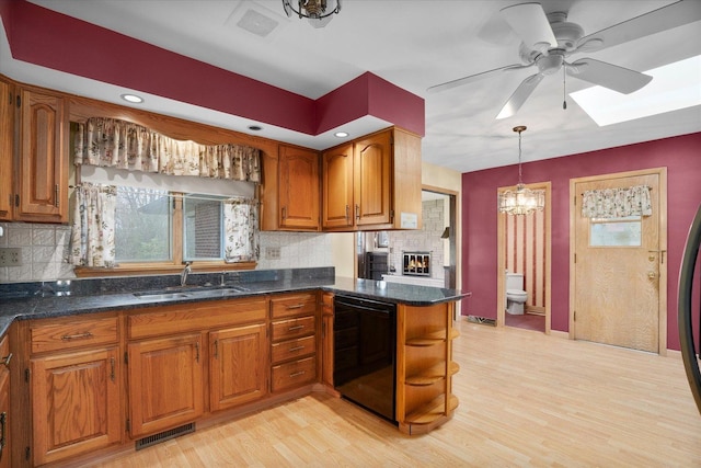 745 Konen Ave, Aurora, IL 60505 - kitchen with a sink, dishwasher, brown cabinets, a skylight, and a ceiling fan