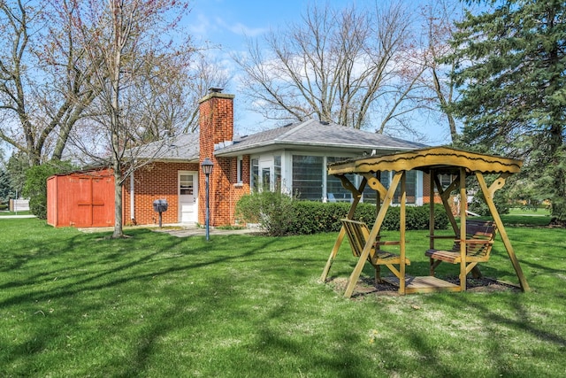 745 Konen Ave, Aurora, IL 60505 - rear view of house featuring a yard, a chimney, and brick siding