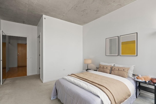 bedroom with light colored carpet and baseboards