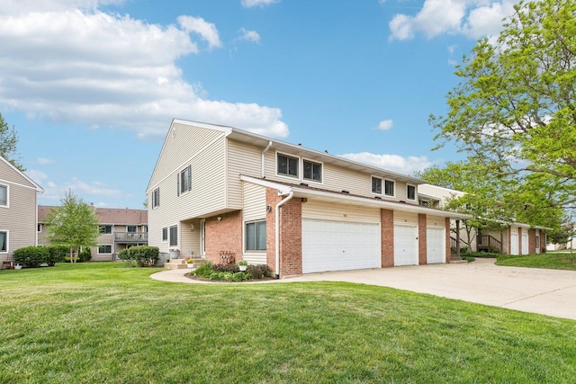992 Hidden Lake Dr, Buffalo Grove, IL 60089 - townhome / multi-family property featuring concrete driveway, brick siding, a front yard, and an attached garage