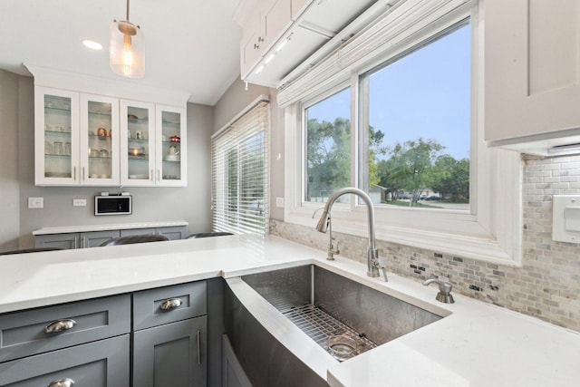 992 Hidden Lake Dr, Buffalo Grove, IL 60089 - kitchen featuring a sink, gray cabinetry, backsplash, and glass insert cabinets