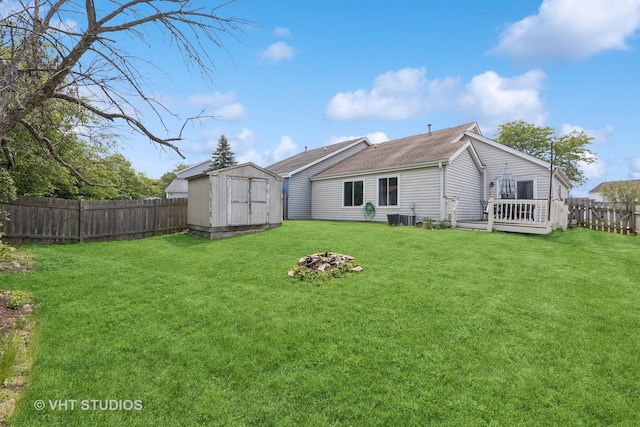 1247 Trinity Dr, Carol Stream, IL 60188 - back of property featuring a storage shed, a fenced backyard, a wooden deck, and a shingled roof