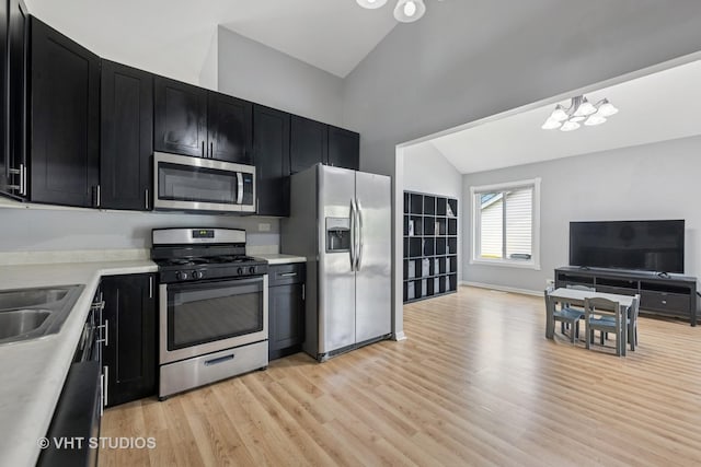 1247 Trinity Dr, Carol Stream, IL 60188 - kitchen with appliances with stainless steel finishes, dark cabinets, vaulted ceiling, light countertops, and open floor plan