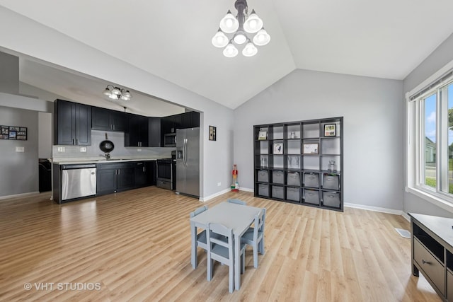 1247 Trinity Dr, Carol Stream, IL 60188 - kitchen featuring appliances with stainless steel finishes, a chandelier, lofted ceiling, dark cabinetry, and light countertops