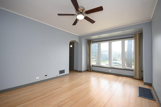 5533 S Menard Ave, Chicago, IL 60638 - spare room with arched walkways, baseboards, ceiling fan, light wood-type flooring, and crown molding
