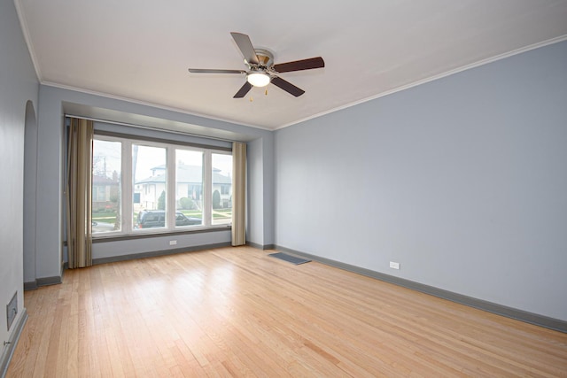 5533 S Menard Ave, Chicago, IL 60638 - empty room featuring crown molding, light wood-style floors, a ceiling fan, arched walkways, and baseboards