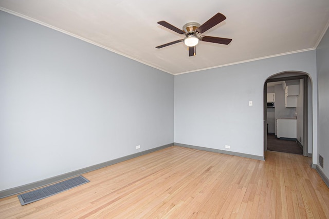 5533 S Menard Ave, Chicago, IL 60638 - empty room featuring arched walkways, a ceiling fan, light wood finished floors, baseboards, and crown molding