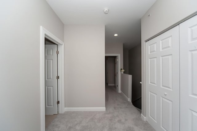 hallway with light carpet, baseboards, and recessed lighting