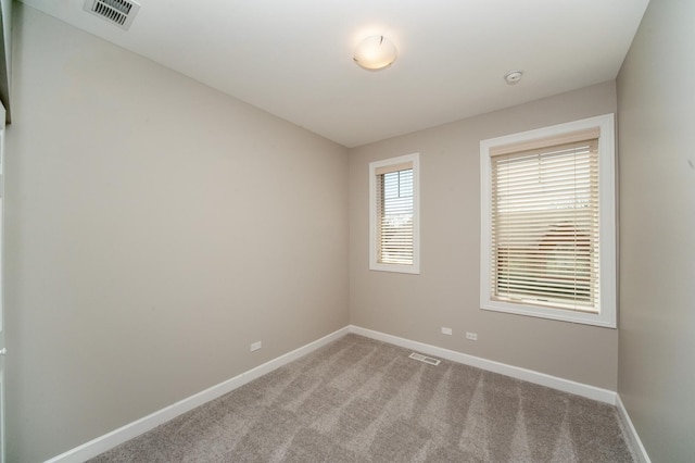 carpeted spare room featuring baseboards