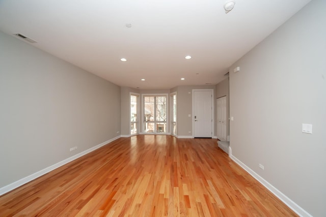 unfurnished room with light wood-type flooring, recessed lighting, and baseboards