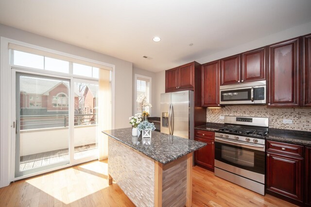 kitchen featuring stainless steel appliances, dark brown cabinets, light wood finished floors, and recessed lighting