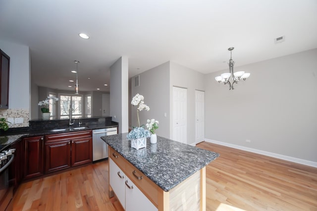 kitchen featuring stainless steel dishwasher, light wood-style floors, a chandelier, a sink, and recessed lighting