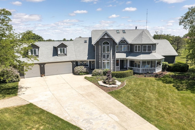 56 Huntsman Ln, Plano, IL 60545 - view of front of house with covered porch, a front lawn, driveway, a garage, and a shingled roof