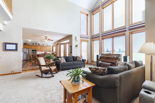 56 Huntsman Ln, Plano, IL 60545 - living room with high vaulted ceiling, light carpet, baseboards, and a ceiling fan