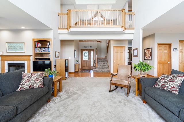 56 Huntsman Ln, Plano, IL 60545 - living room featuring a high ceiling, stairway, a fireplace, and carpet flooring