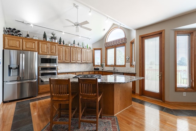 56 Huntsman Ln, Plano, IL 60545 - kitchen with appliances with stainless steel finishes, rail lighting, a sink, light wood-style floors, and a center island