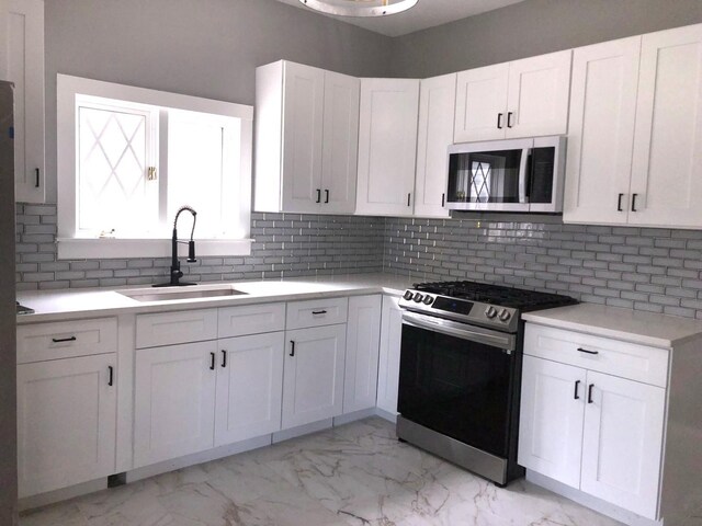 9715 S Ave N Ave, Chicago, IL 60617 - kitchen featuring white microwave, stainless steel range oven, a sink, light marble finish floors, and white cabinets