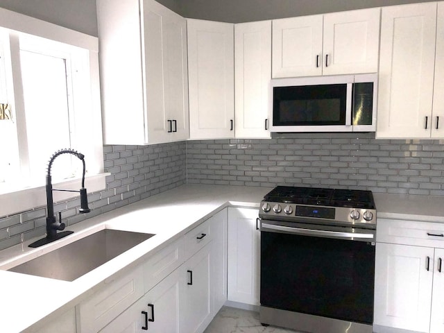 9715 S Ave N Ave, Chicago, IL 60617 - kitchen with stainless steel gas range oven, a sink, white microwave, backsplash, and light countertops